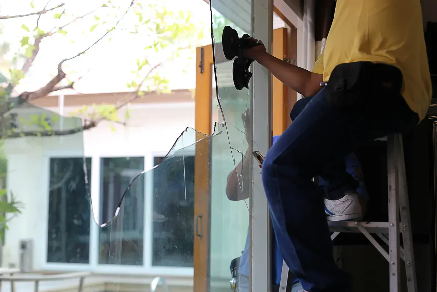 Vitrier posant à la ventouse une glace de devanture à Ablon-sur-Seine